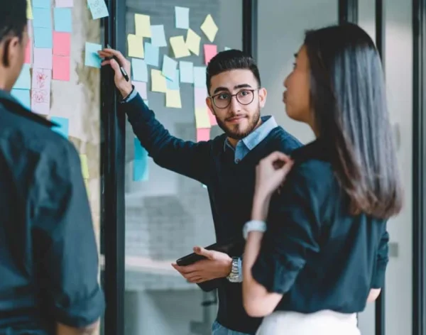 RS_RW-C54-man presenting with sticky notes to colleagues-935x530px