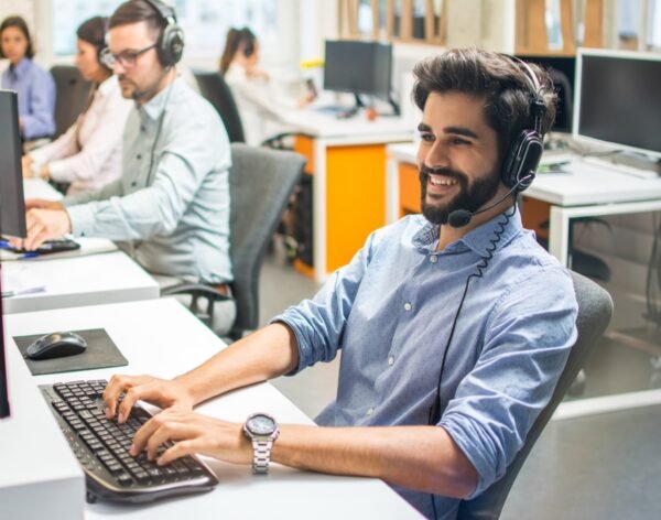 Handsome male customer service executive working at office with his colleagues